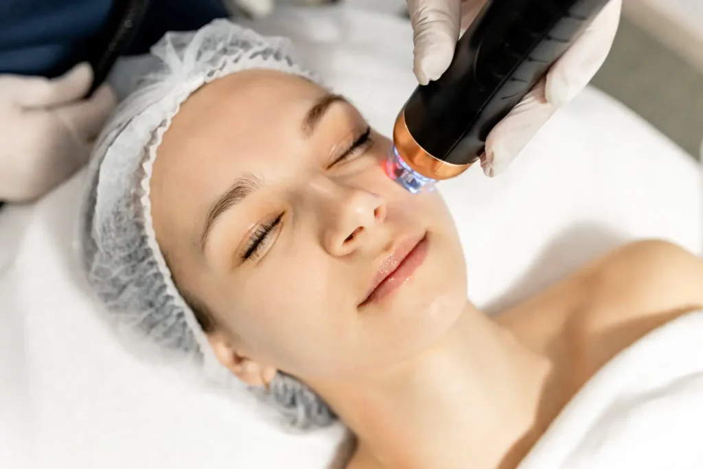 aesthetic device used on woman’s cheek during professional facial treatment
